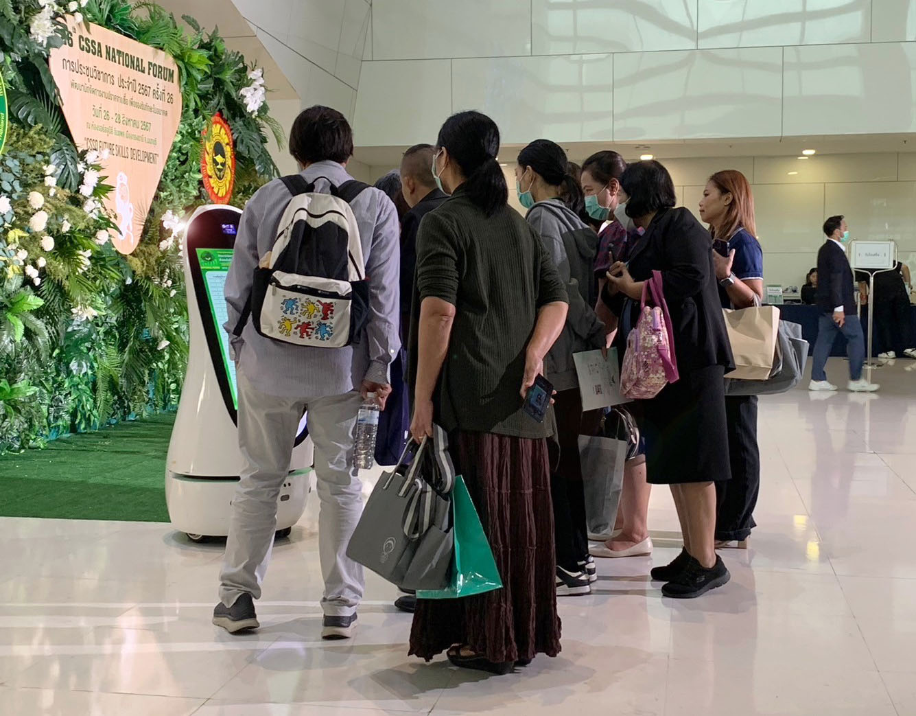 กลุ่มคนยืนรอบหุ่นยนต์ HapyBot รุ่น P ภายในงานประชุมวิชาการแห่งชาติ CSSA ที่อิมแพค ชาเลนเจอร์