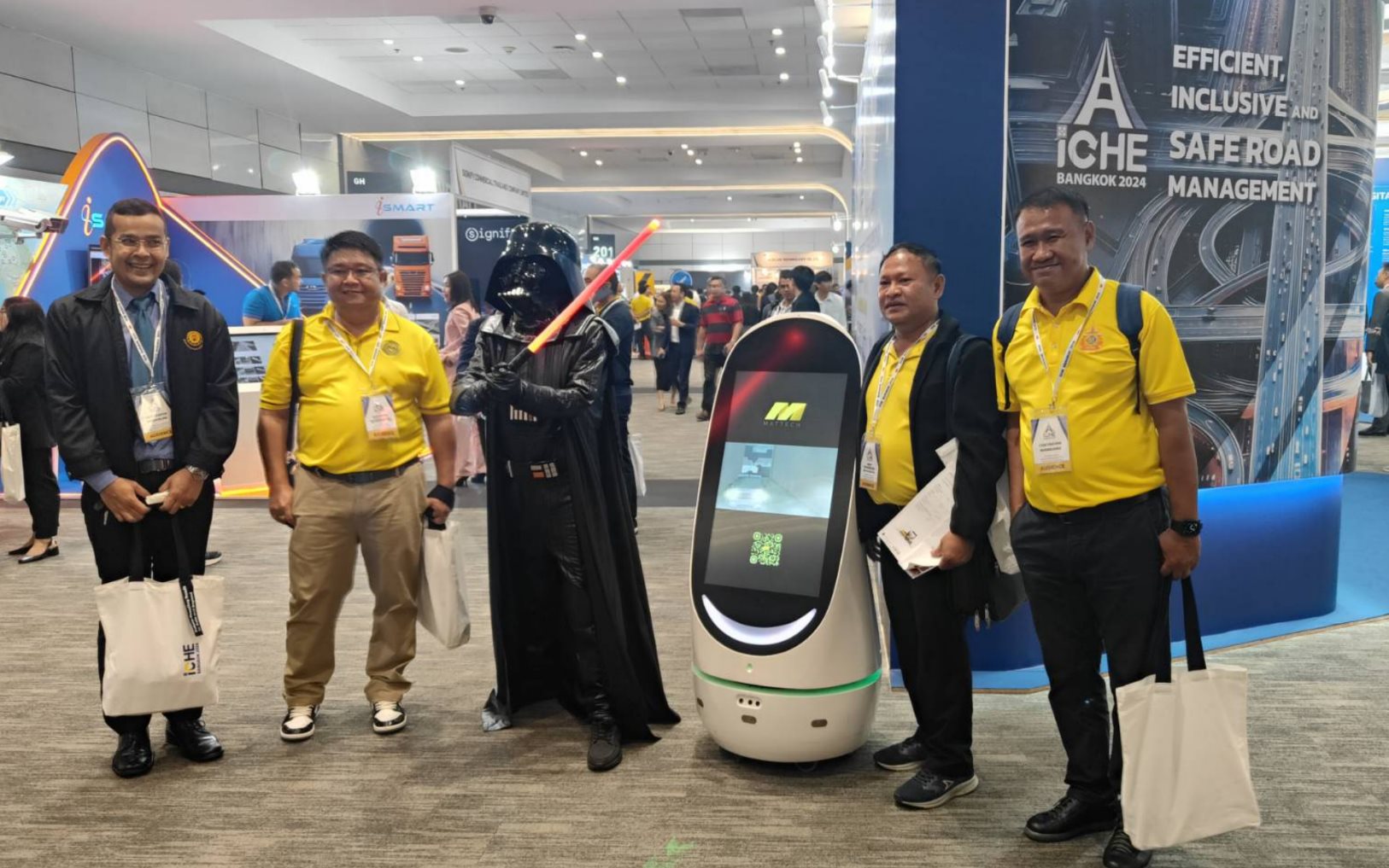 ผู้เข้าร่วมงานถ่ายภาพร่วมกับดาร์ธ เวเดอร์และหุ่นยนต์ประชาสัมพันธ์ HAPYbot ในงาน iCHE Bangkok 2024
