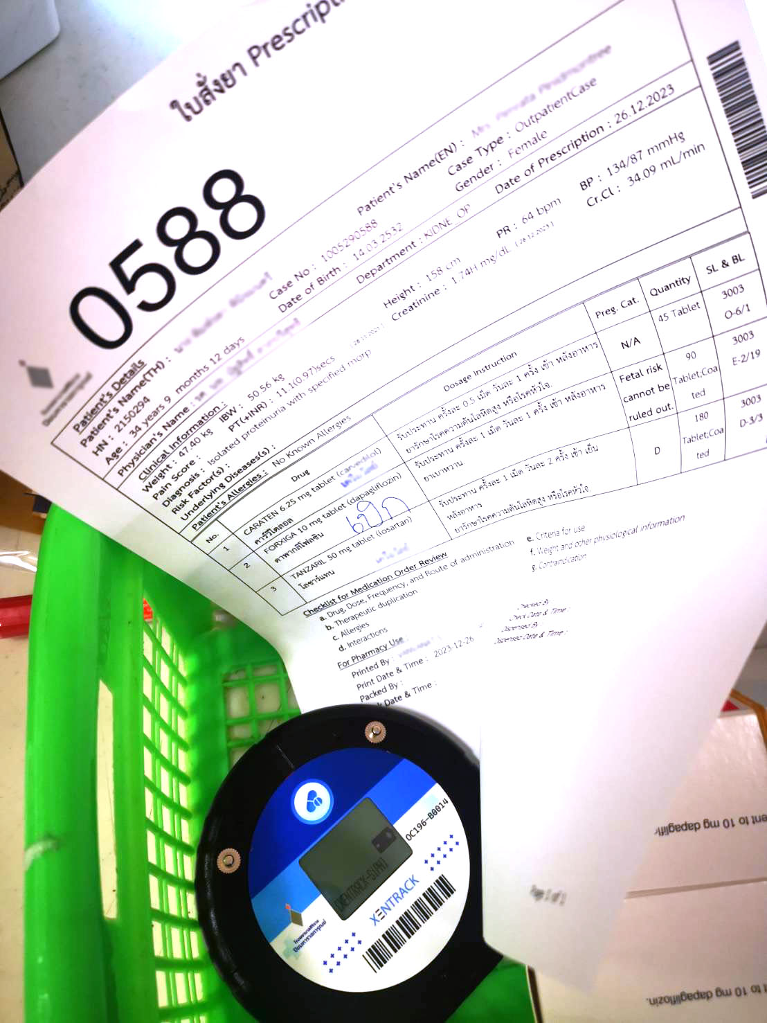 A prescription form with Beeper 0588 in a green basket, ready for dispensing in a hospital pharmacy. | ใบสั่งยาพร้อมบี๊บเปอร์หมายเลข 0588 ในตะกร้าสีเขียว เตรียมพร้อมสำหรับการจ่ายยาภายในห้องยาโรงพยาบาล