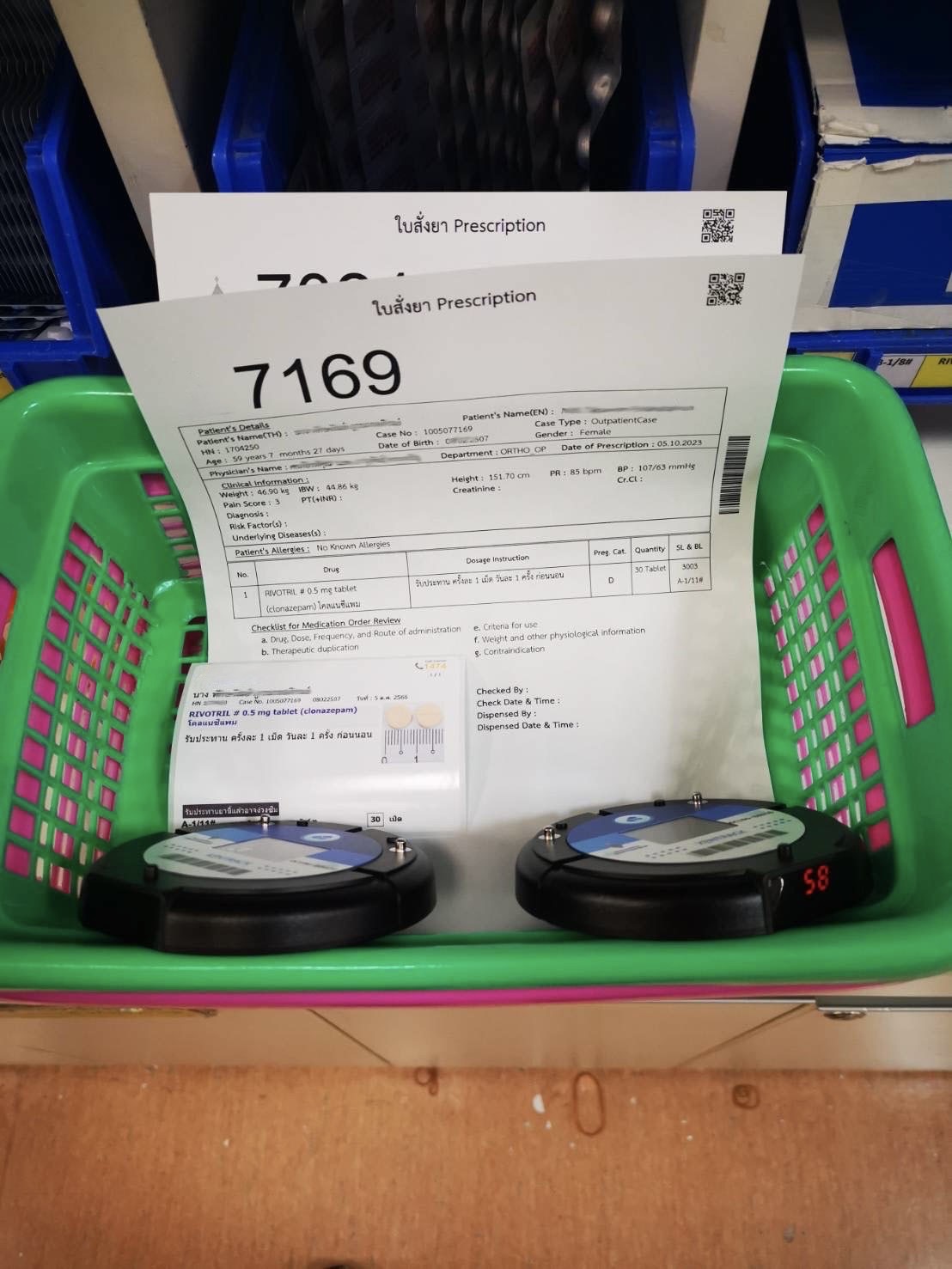 Two hospital medication baskets with Beeper IDs 7169 and 7035 in a pharmacy setting. | ตะกร้ายาในโรงพยาบาล 2 ใบพร้อมบี๊บเปอร์หมายเลข 7169 และ 7035 ในห้องยา