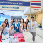 Medical professionals from Siriraj Piyamaharajgarun Hospital posing with an automatic dispensing machine at a healthcare exhibition in Thailand
