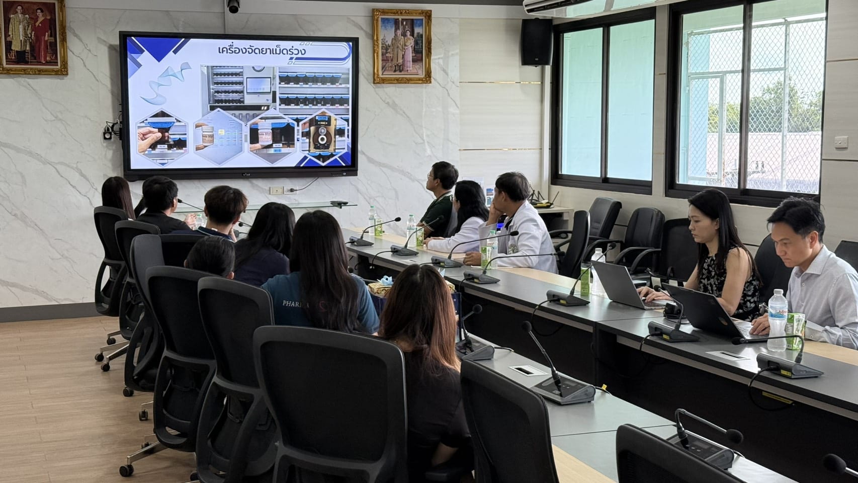 คณะบุคลากรโรงพยาบาลศรีสะเกษรับฟังบรรยายสไลด์นำเสนอระบบเครื่องจัดยาเม็ดร่วงอัตโนมัติ HAPYmed ในห้องประชุม รพร.สระแก้ว